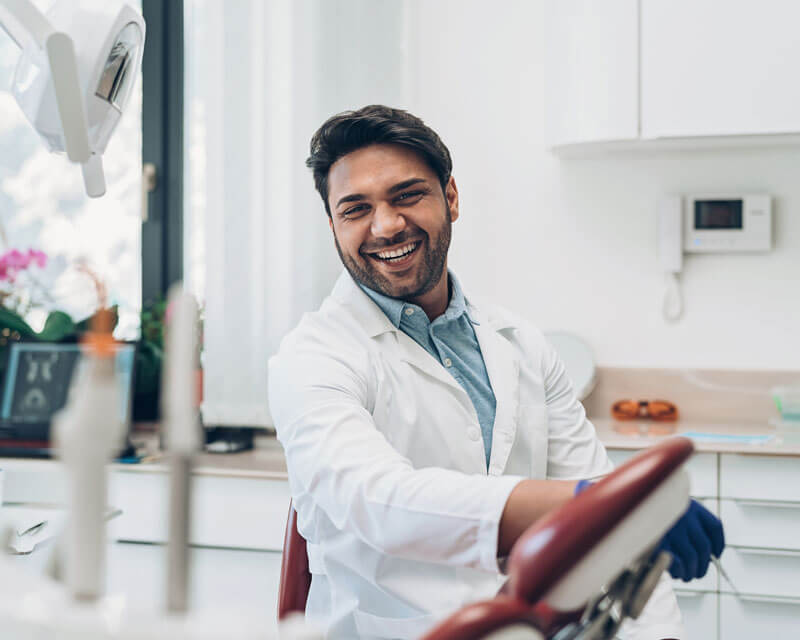 Smiling dentist in his office